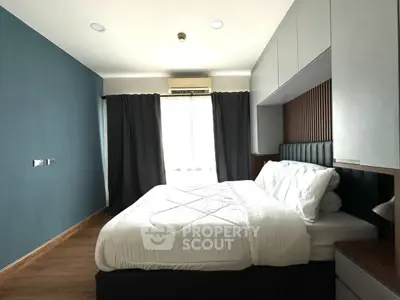 Modern bedroom with stylish decor and ample natural light, featuring a comfortable bed and sleek cabinetry.
