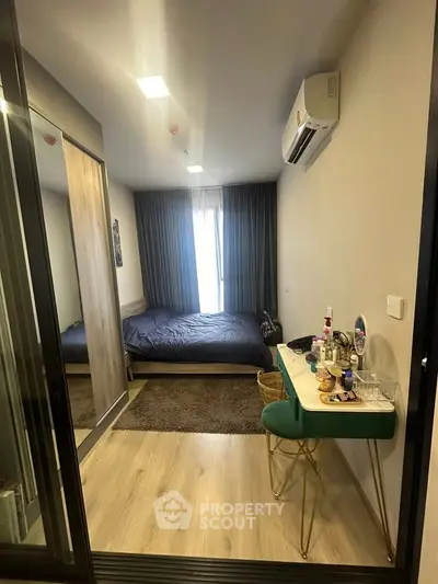 Cozy bedroom with modern decor, featuring a stylish vanity and ample natural light.