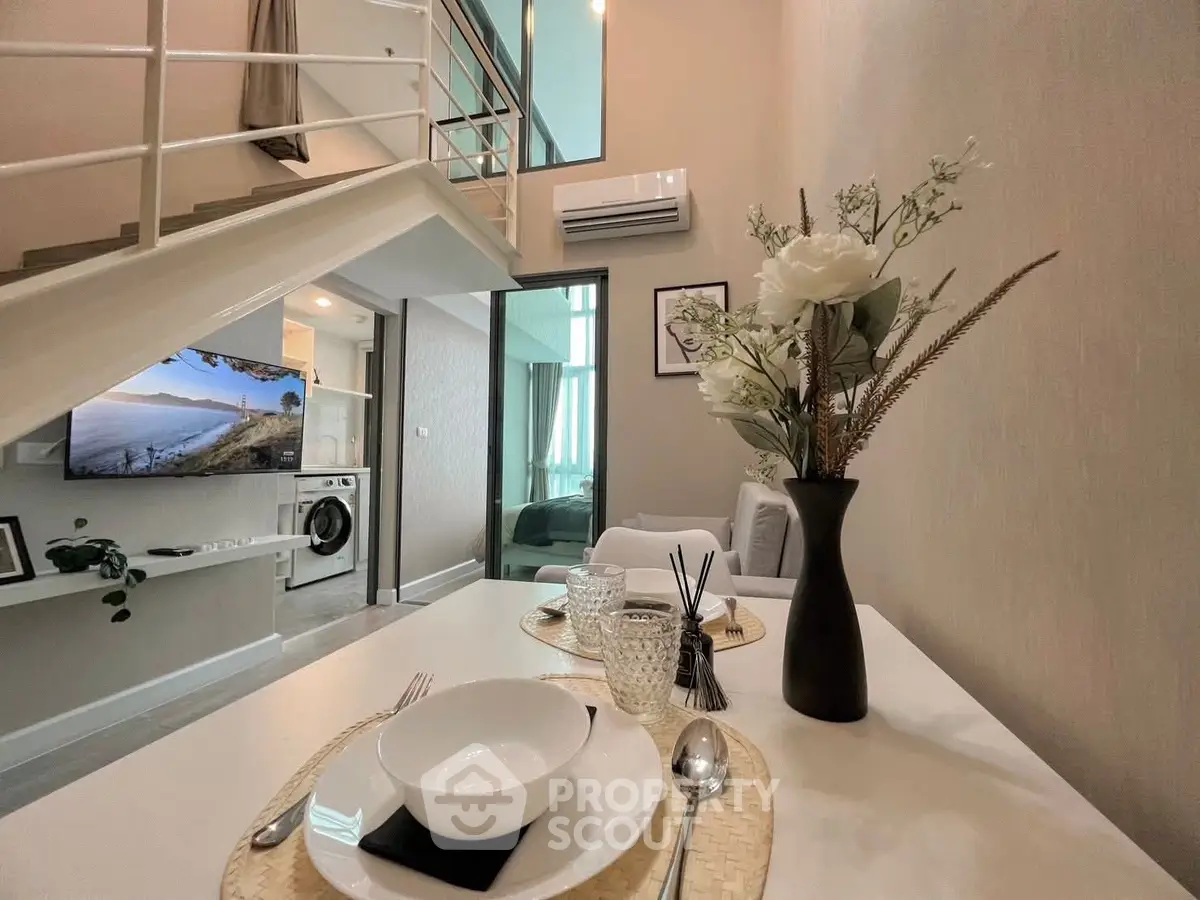 Modern loft apartment with stylish decor, open living area, and elegant dining setup.