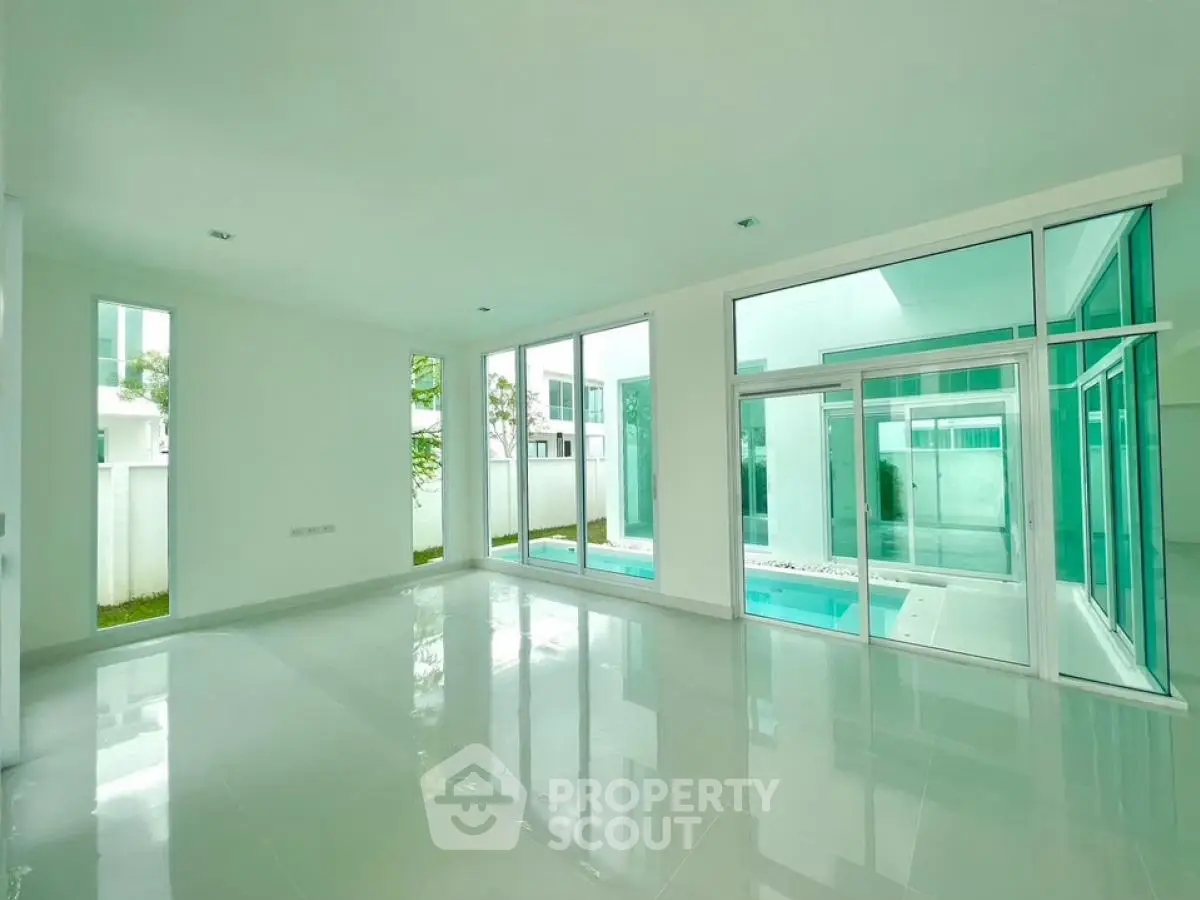 Spacious modern living room with large windows and pool view