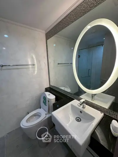 Modern bathroom with illuminated mirror and sleek fixtures