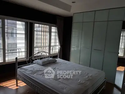 Spacious bedroom with large windows and modern wardrobe
