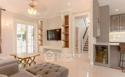 Spacious living room with elegant decor and natural light, featuring a built-in TV unit and stylish furniture.
