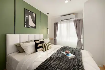 Modern bedroom with stylish decor and natural light, featuring a cozy bed and elegant green accent wall.