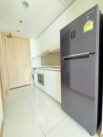 Modern kitchen with sleek appliances and closed layout in a stylish apartment.