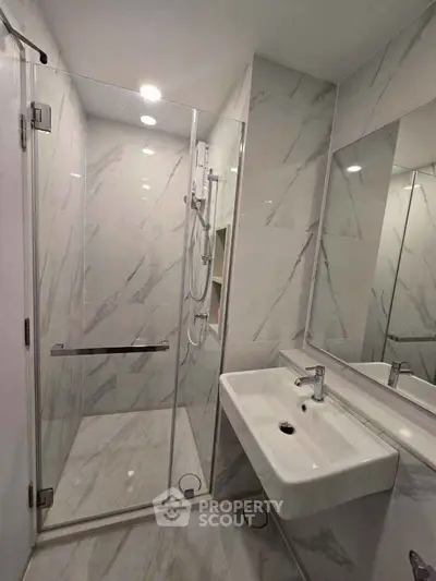 Modern bathroom with sleek shower and elegant sink in a stylish real estate property.