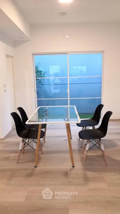Modern dining area with glass table and stylish chairs, bright natural light