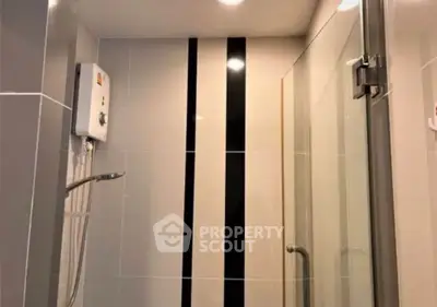 Modern bathroom with sleek shower and water heater in contemporary design.