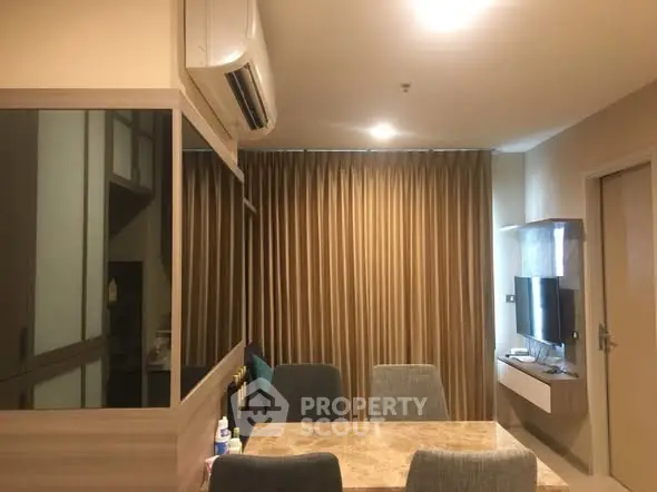 Modern living room with dining area and wall-mounted TV in cozy apartment.