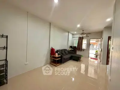 Spacious living room with modern sofa and ceiling fan, ideal for comfortable living.