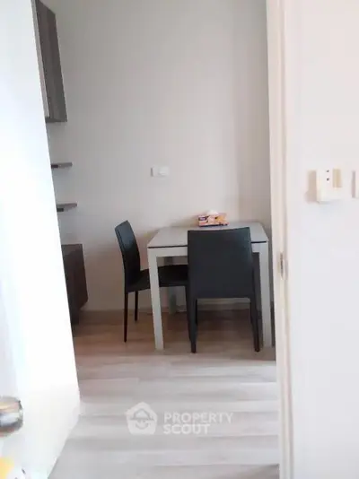Cozy dining nook with modern table and chairs in a compact apartment setting.