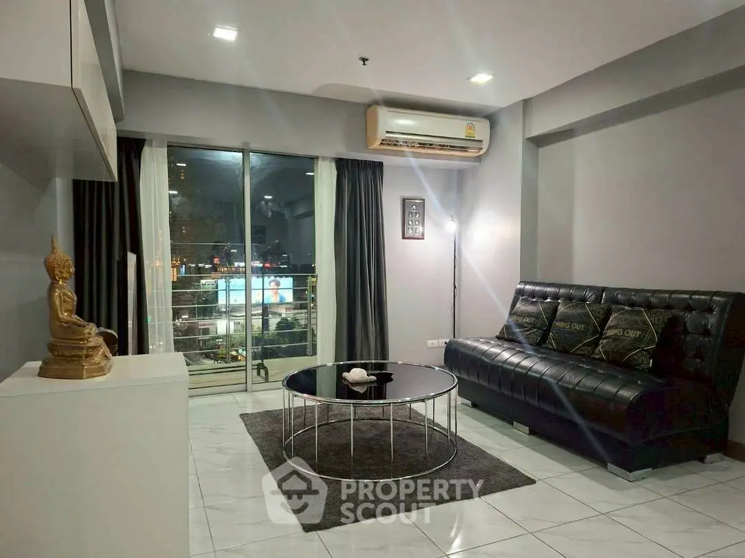 Modern living room with sleek furniture and city view balcony access.