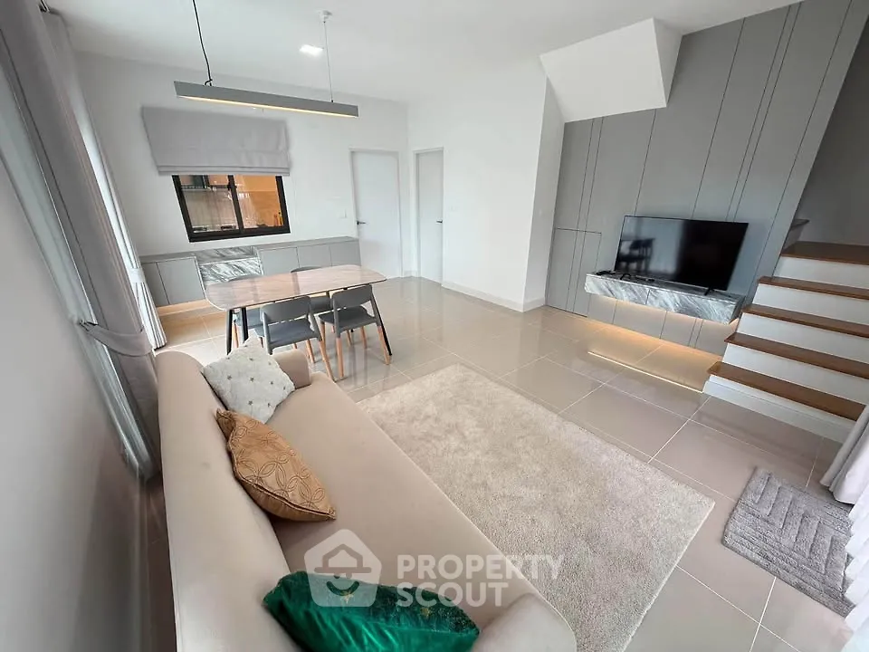 Modern living room with sleek design, cozy sofa, and stylish dining area in open layout.