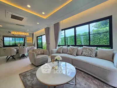 Luxurious living room with elegant decor and large windows offering lush garden views.