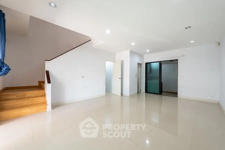 Spacious modern living room with staircase and large windows