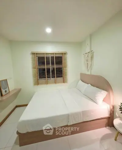 Cozy bedroom with modern decor and soft lighting, perfect for relaxation.