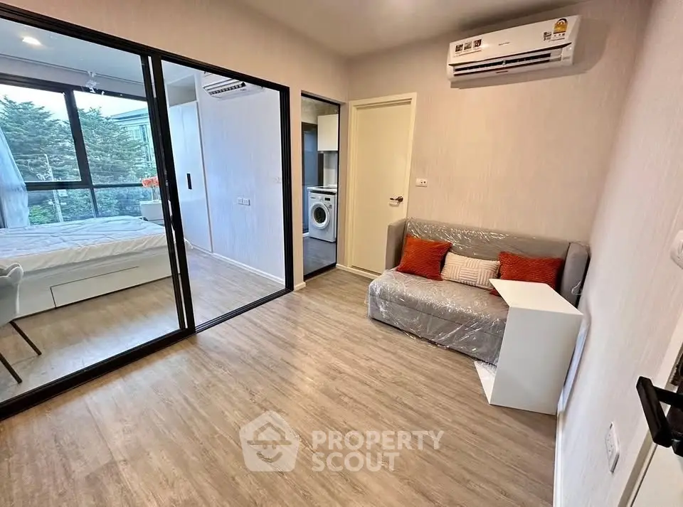 Modern apartment interior with cozy living room and bedroom view, featuring air conditioning and stylish decor.