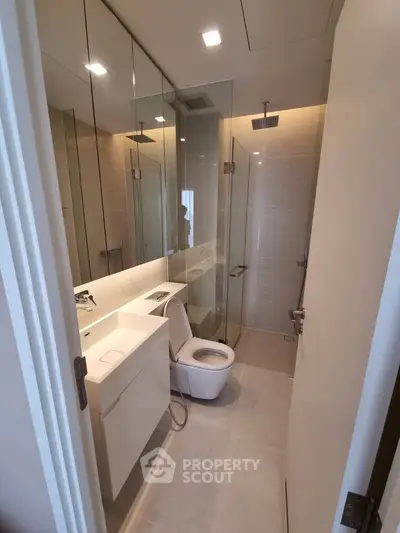 Modern bathroom with glass shower and sleek fixtures in a contemporary apartment.