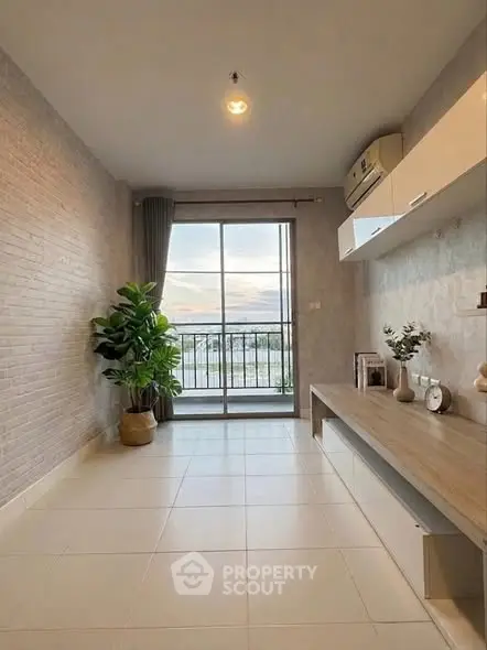 Spacious living room with large window and balcony view, modern decor and natural light.