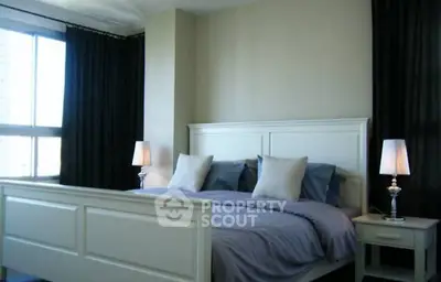 Spacious bedroom with elegant decor and large window for natural light.