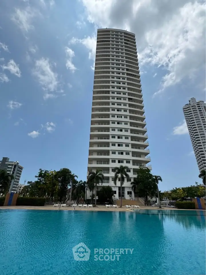 Stunning high-rise building with poolside view and lush surroundings