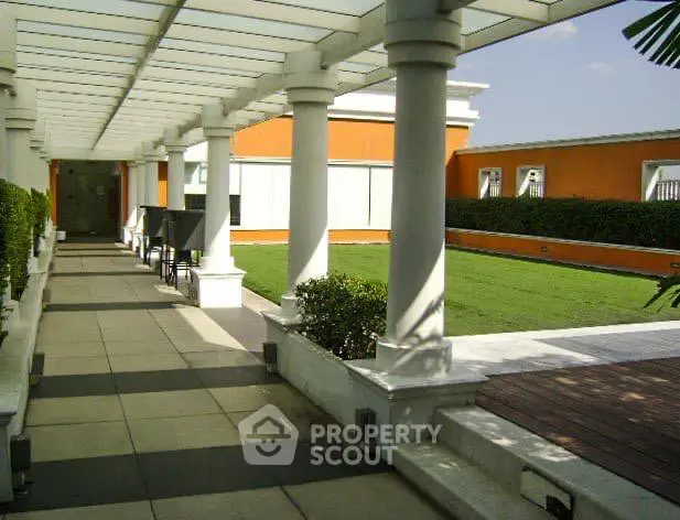 Luxurious rooftop garden with elegant columns and lush greenery, perfect for relaxation and gatherings.