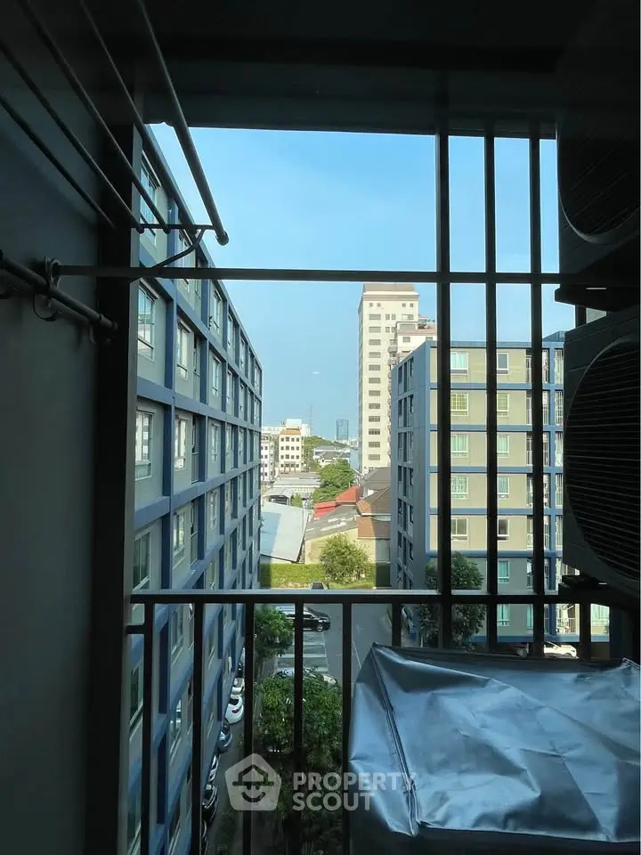Urban apartment view with cityscape and neighboring buildings from a balcony.