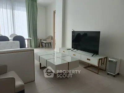 Modern living room with sleek furniture and large TV, perfect for relaxation and entertainment.