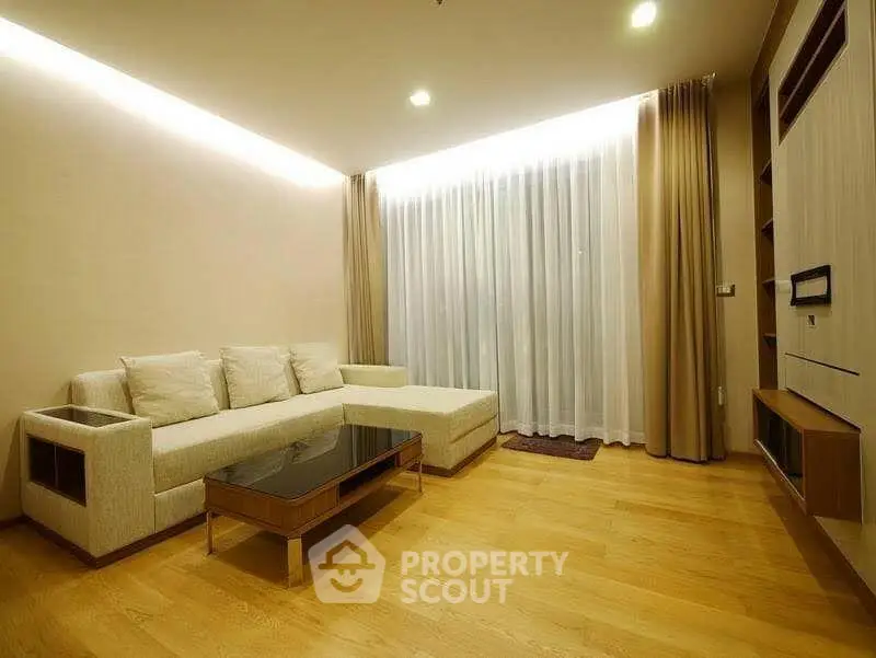 Elegant living room with modern furniture and floor-to-ceiling windows in a cozy apartment.