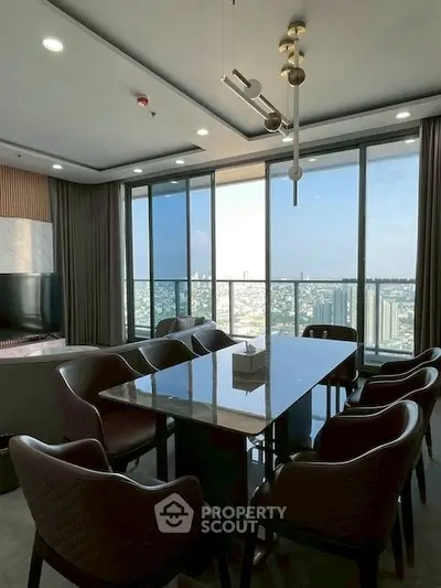 Luxurious dining area with panoramic city view in modern high-rise apartment.