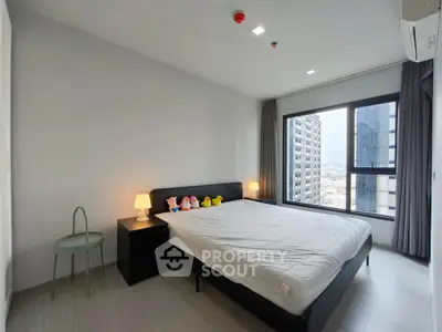Modern bedroom with large window and city view in high-rise apartment