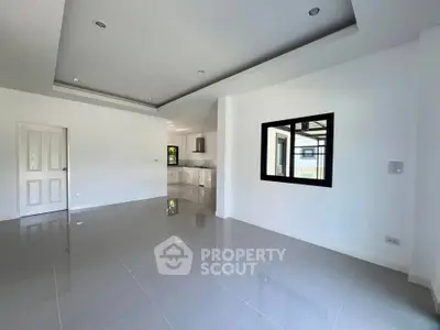 Spacious modern living room with sleek tile flooring and open kitchen layout.