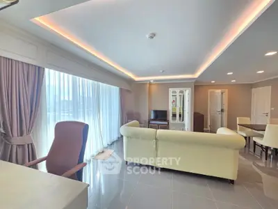 Spacious modern living room with elegant lighting and large windows offering natural light.