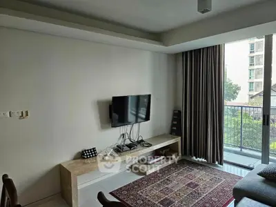 Modern living room with wall-mounted TV and large balcony view, featuring elegant decor and natural light.