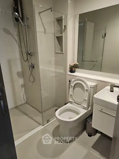 Modern bathroom with glass shower and sleek fixtures in contemporary apartment.