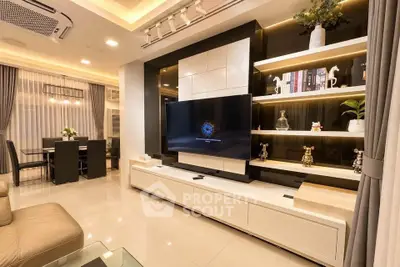 Luxurious modern living room with sleek design and ambient lighting, featuring a large flat-screen TV and elegant decor.