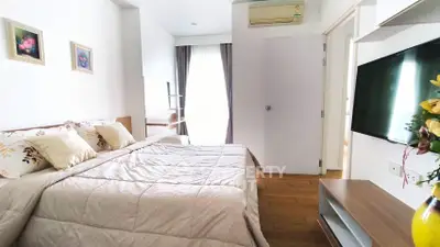 Modern bedroom with cozy bedding and wall-mounted TV in a stylish apartment.