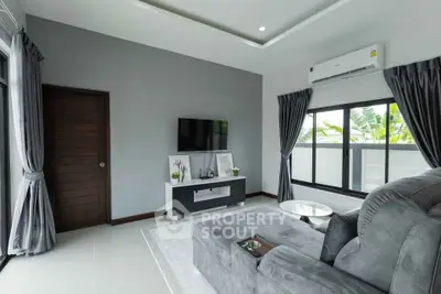 Modern living room with sleek furniture and large windows for natural light.