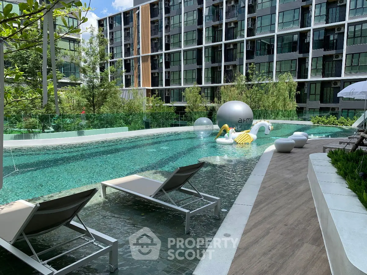 Luxurious apartment complex with modern pool and stylish loungers, perfect for relaxation and leisure.