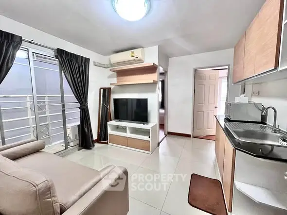 Modern living room with sleek furniture and open kitchen layout in a stylish apartment.