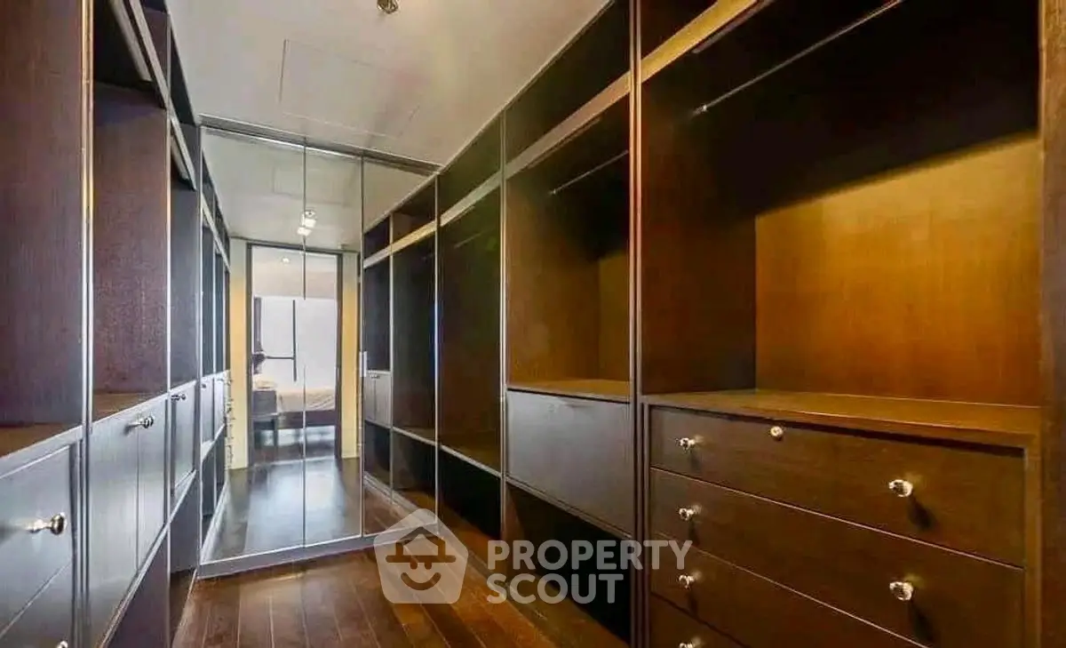 Luxurious walk-in closet with ample storage and elegant wooden finishes.