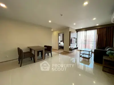 Spacious open-plan living room with dining area and large windows in modern apartment.