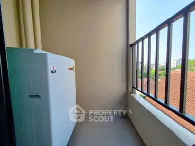 Charming balcony with washing machine and scenic view of rooftops and greenery.