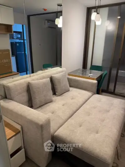 Modern living room with stylish sofa bed and dining area in compact apartment