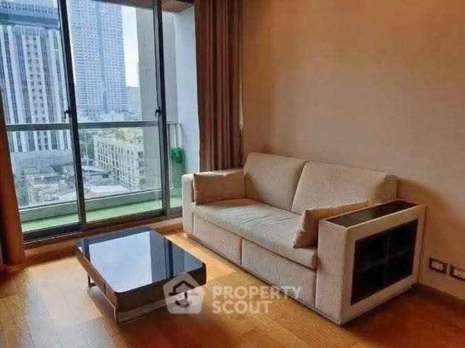 Modern living room with city view, featuring a cozy sofa and sleek coffee table.