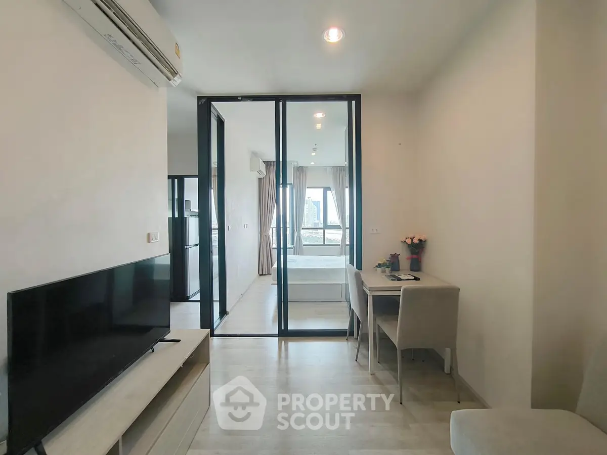 Modern apartment interior with open layout and city view, featuring a cozy living area and stylish bedroom.