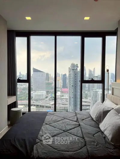 Luxurious bedroom with stunning city view through floor-to-ceiling windows.