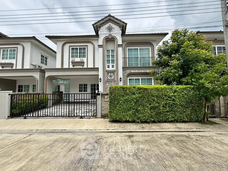 Elegant two-story house with classic facade and lush greenery in a serene neighborhood.