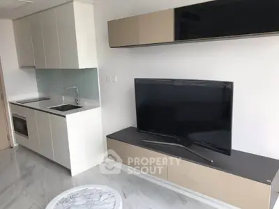 Modern living room with sleek kitchen and flat-screen TV, featuring minimalist design and marble flooring.