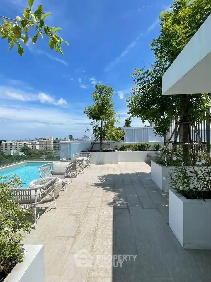 Luxurious rooftop pool area with stunning city views and modern seating.